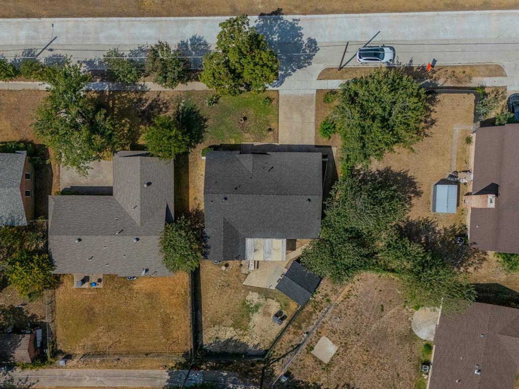 6320 Old Ox Road Dallas, TX 75241 - Photo 17 of 17 Asphalt shingle roof, paved driveway, mature trees, concrete patio, detached storage shed