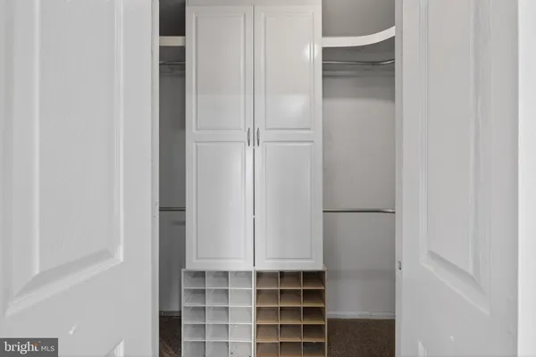 a view of empty room with wooden floor and kitchen view