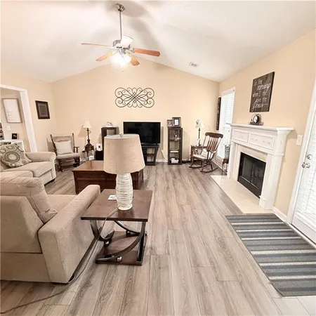 a living room with furniture a fireplace and a flat screen tv