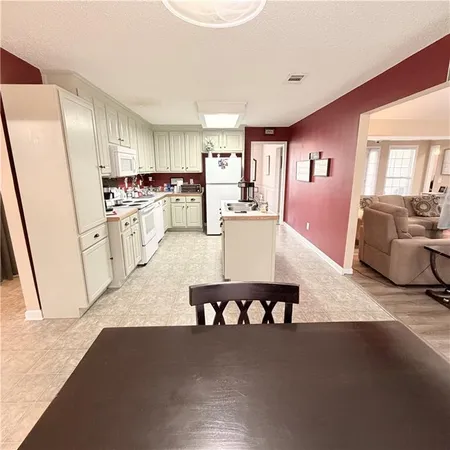 a kitchen with a sink a stove a refrigerator and cabinets