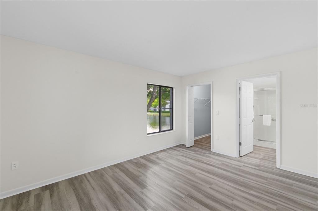 1135 Pine Ridge Circle West, Unit A2 Tarpon Springs, FL 34688 - Photo 25 of 63 a view of an empty room with wooden floor and a window