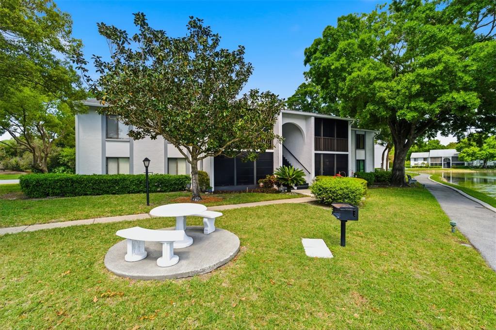 1135 Pine Ridge Circle West, Unit A2 Tarpon Springs, FL 34688 - Photo 40 of 63 a swimming pool with lots of tress in front of it