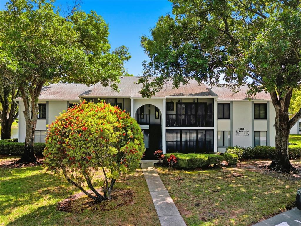 1135 Pine Ridge Circle West, Unit A2 Tarpon Springs, FL 34688 - Photo 43 of 63 a front view of a house with garden