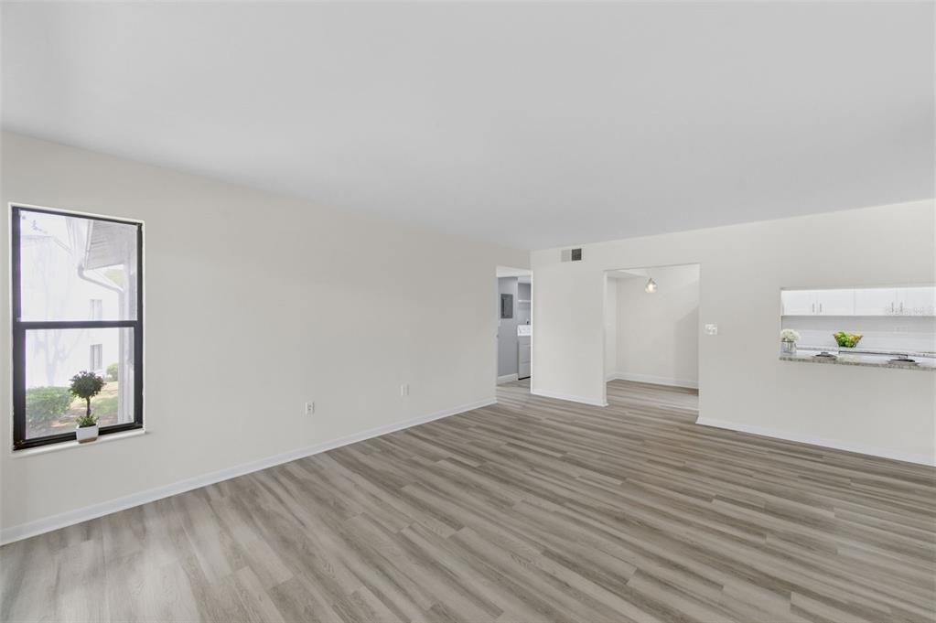 1135 Pine Ridge Circle West, Unit A2 Tarpon Springs, FL 34688 - Photo 7 of 63 a view of an empty room with wooden floor and a window