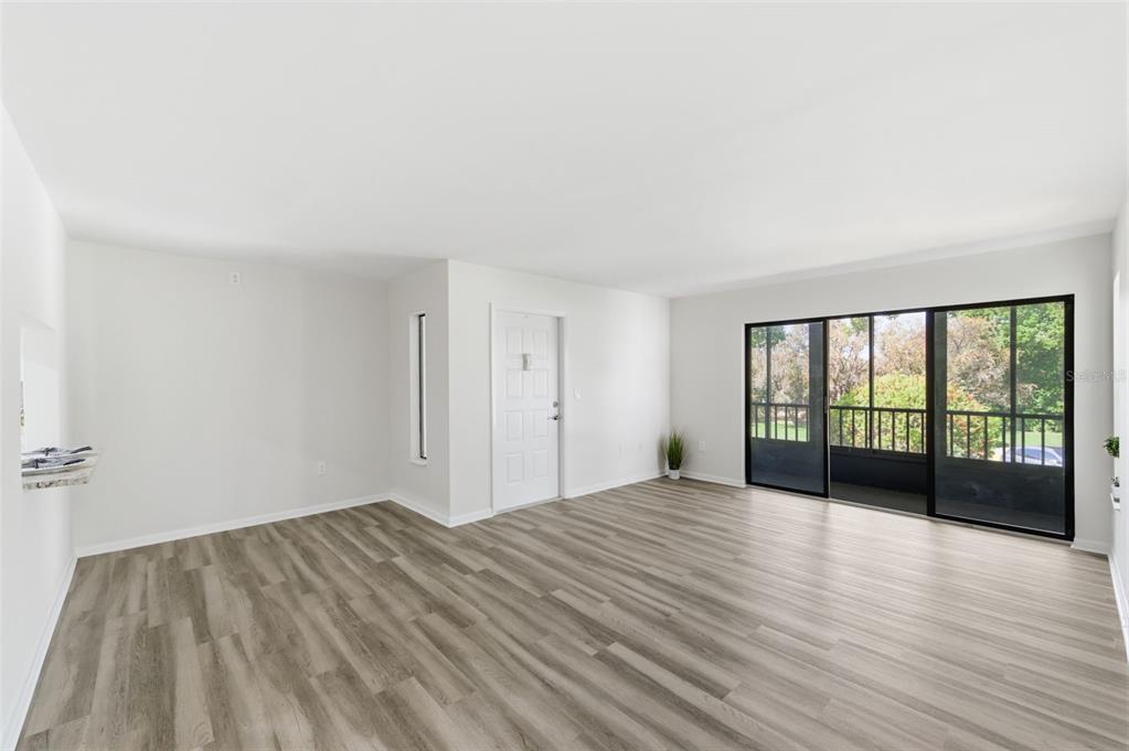 1135 Pine Ridge Circle West, Unit A2 Tarpon Springs, FL 34688 - Photo 8 of 63 a view of empty room with wooden floor and fan