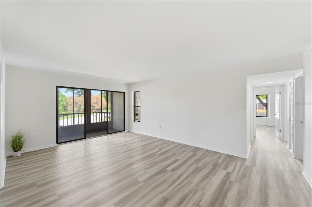 1135 Pine Ridge Circle West, Unit A2 Tarpon Springs, FL 34688 - Photo 10 of 63 a view of an empty room with wooden floor and a window