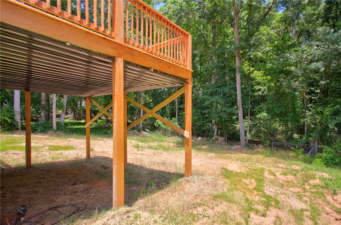 223 Maple Drive Anderson, SC 29621 - Photo 37 of 45 A spacious backyard with mature trees provides a private natural setting beneath a newly constructed wood deck.