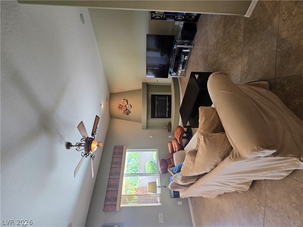 2567 Dirleton Place Henderson, NV 89044 - Photo 25 of 67 A well-lit living space features high ceilings and a central fireplace.