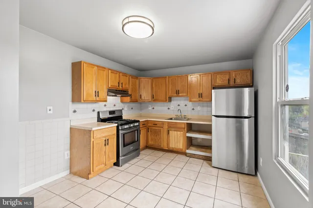a kitchen with stainless steel appliances granite countertop a refrigerator sink and stove