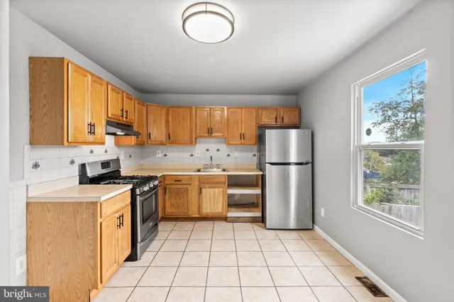 a kitchen with granite countertop a stove top oven sink and cabinets