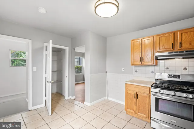 a kitchen with granite countertop a refrigerator stove and sink