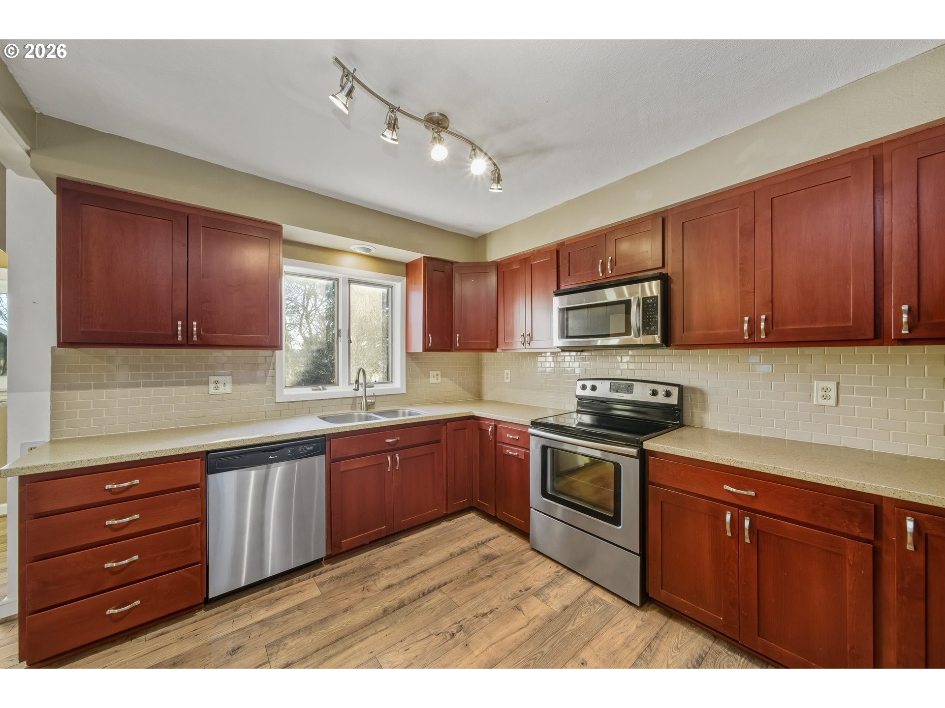 2507 6th Street Tillamook, OR 97141 - Photo 18 of 45 a kitchen with stainless steel appliances granite countertop wooden cabinets a stove top oven with wooden floor