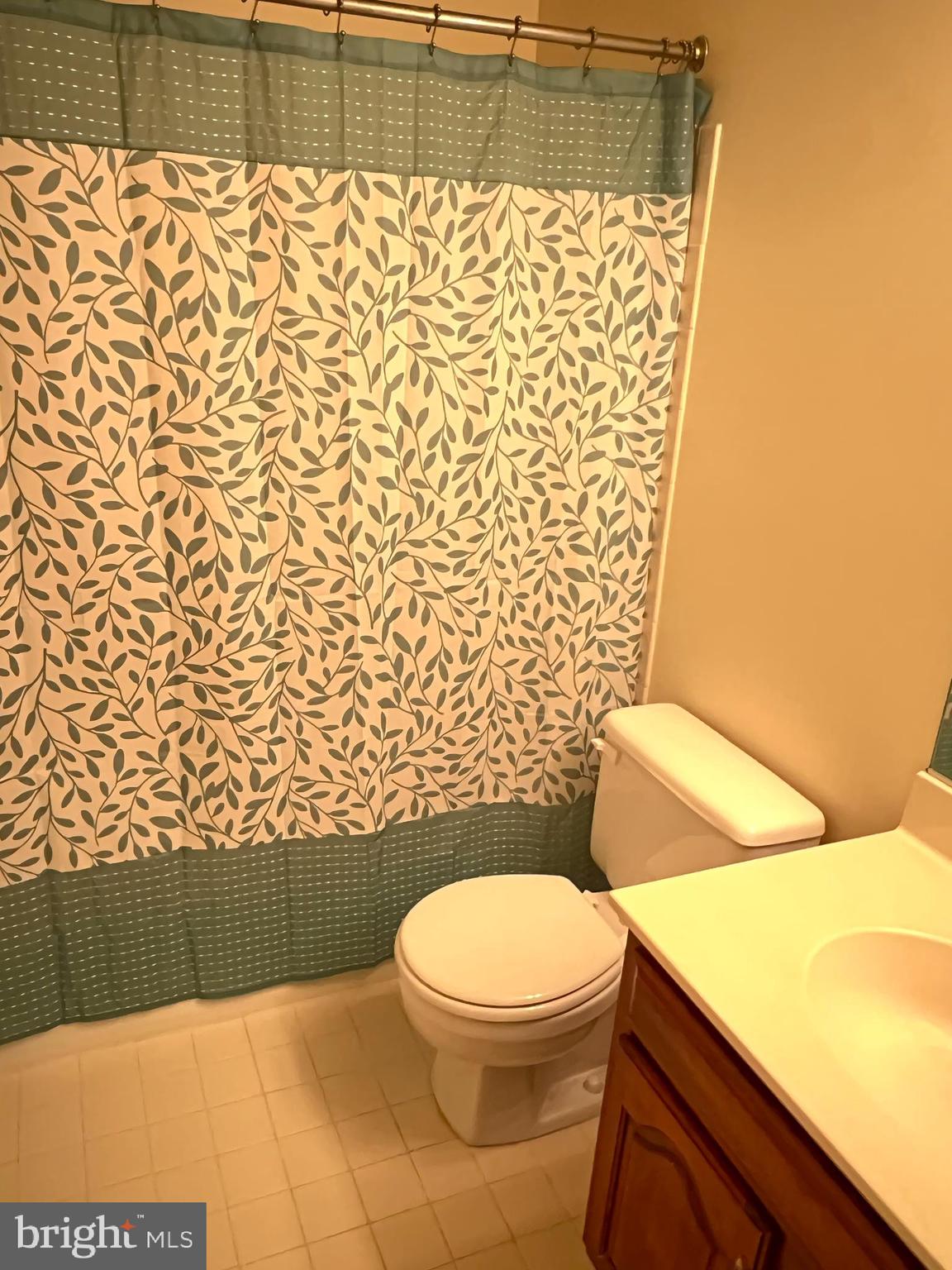 10775 Brewer House Road Rockville, MD 20852 - Photo 12 of 19 a bathroom with a toilet and a shower curtain