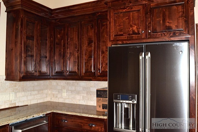 355 Pepperroot Road Boone, NC 28607 - Photo 6 of 8 a kitchen with granite countertop wooden cabinets and a refrigerator