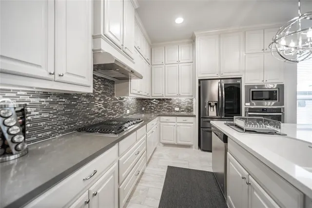 a kitchen with stainless steel appliances a sink stove and refrigerator