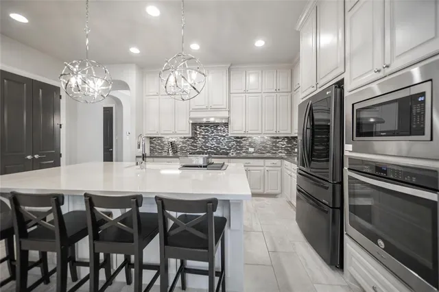 a large kitchen with a table and chairs