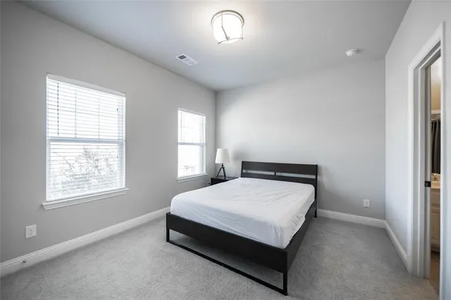 a bed sitting in a bedroom next to a window