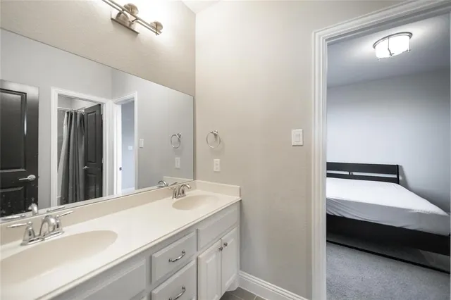 a en suite bathroom with a double vanity sink and a mirror