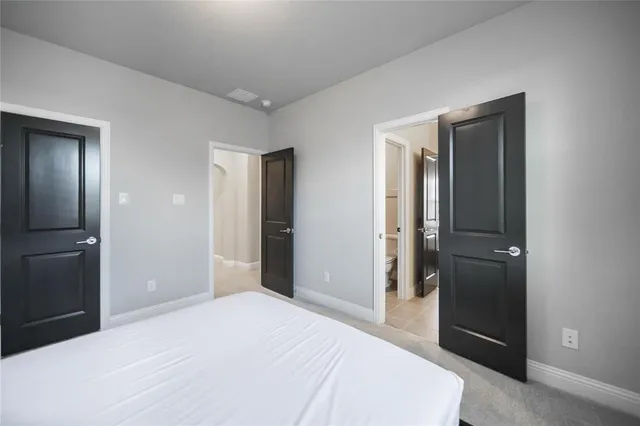 a bedroom with a bed and a large mirror