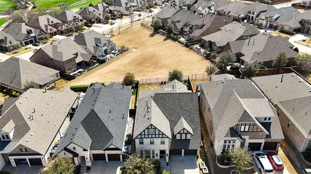 an aerial view of multiple houses with a city street