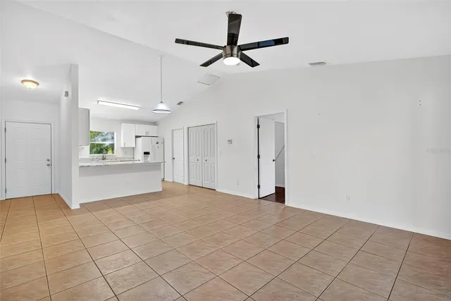 a view of an empty room and kitchen view