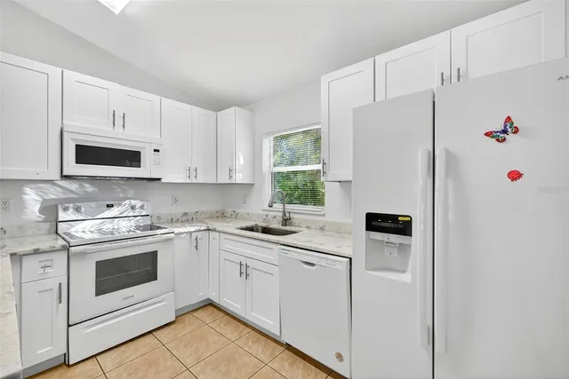 a kitchen with white cabinets sink and white appliances