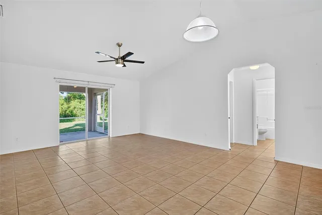 an empty room with fan and windows