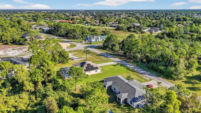 an aerial view of residential houses with outdoor space and swimming pool