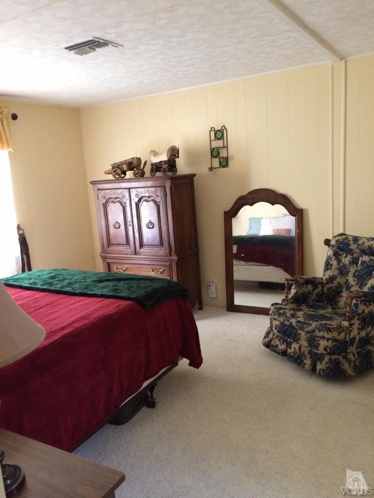 6480 Katherine Road, Unit 83 Simi Valley, CA 93063 - Photo 7 of 9 a bed room with a bed and a chair
