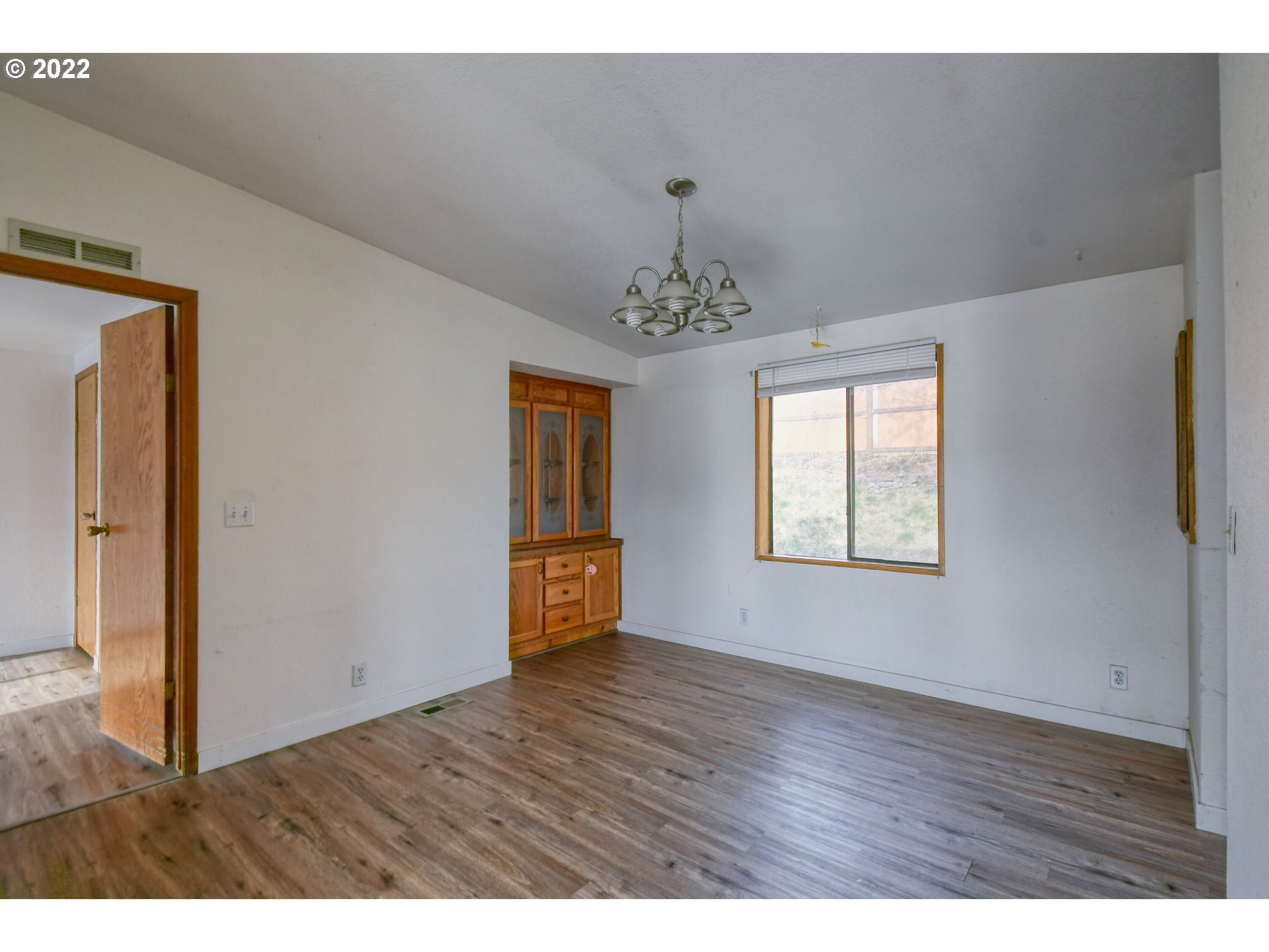 809 Southwest 11th Street Pendleton, OR 97801 - Photo 12 of 32 a view of an empty room with wooden floor and a window