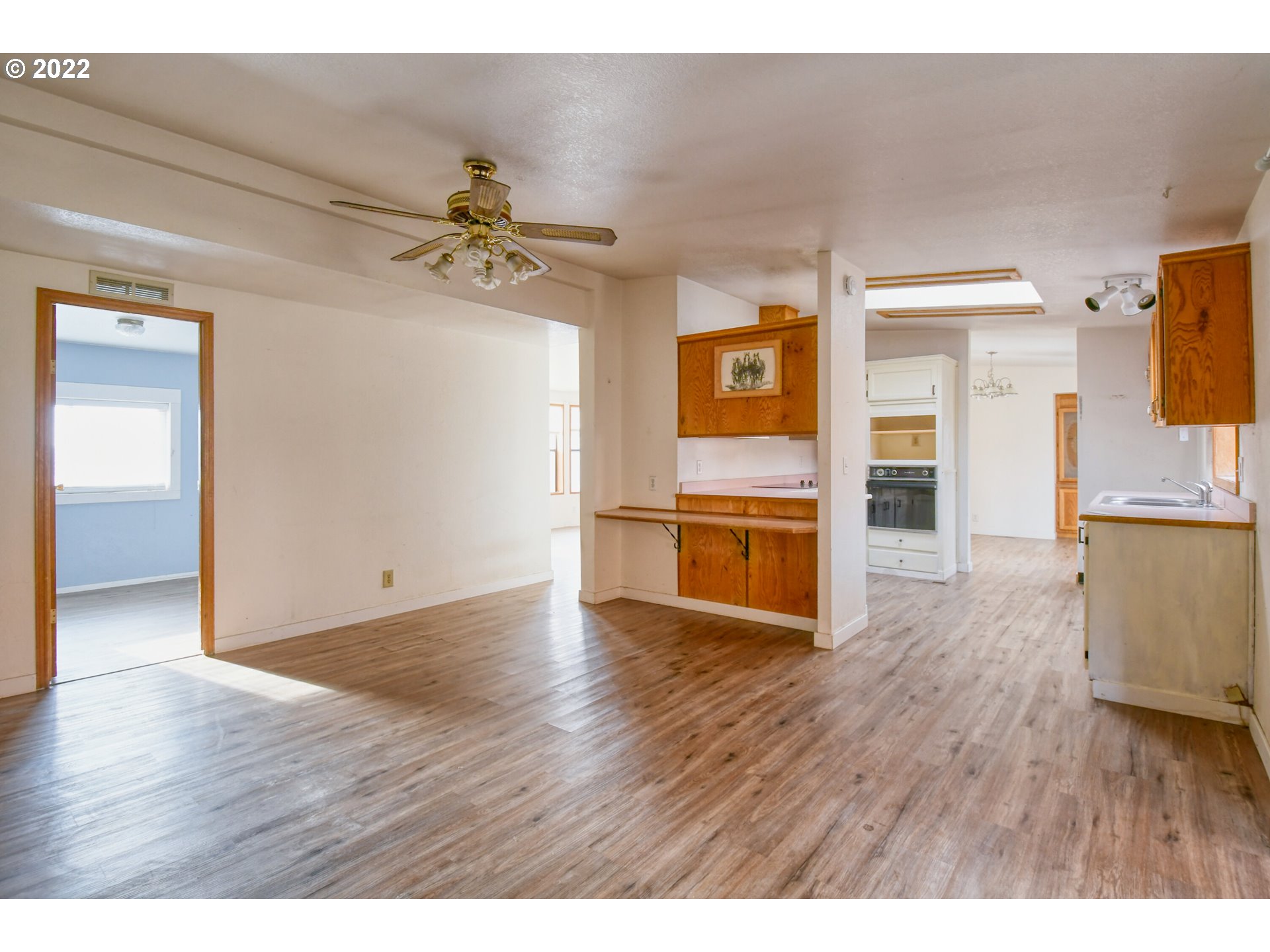 809 Southwest 11th Street Pendleton, OR 97801 - Photo 18 of 32 a view of a kitchen with wooden floor a sink a refrigerator and window