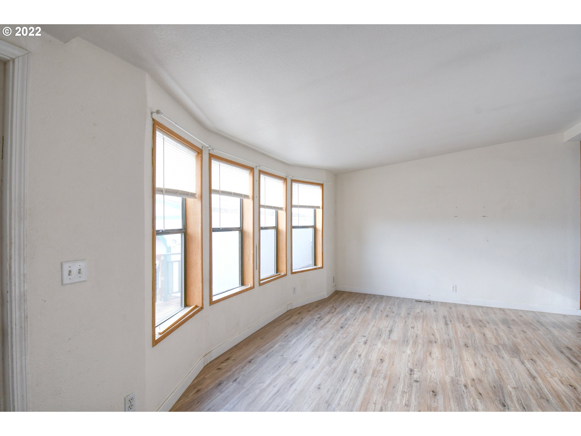 809 Southwest 11th Street Pendleton, OR 97801 - Photo 9 of 32 a view of an empty room with wooden floor and a window
