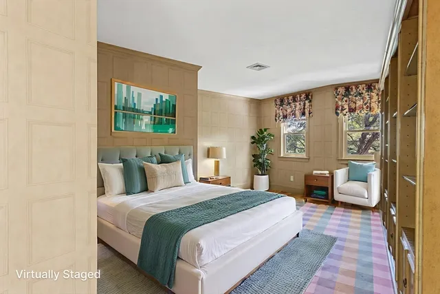 a bedroom with a large bed couch and a window