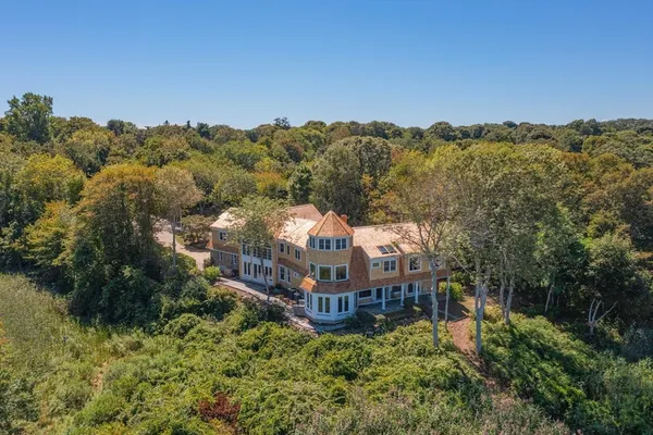 an aerial view of a house with a yard and mountain in the back