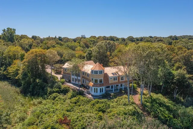 an aerial view of a house with a yard and mountain in the back