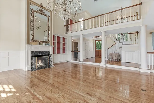 a view of an empty room with wooden floor and a fireplace