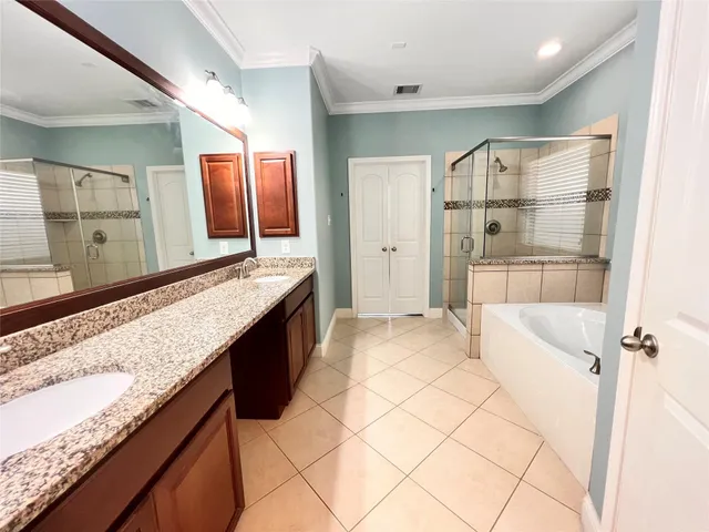 a bathroom with a granite countertop sink a mirror and shower