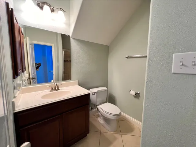 a bathroom with a sink a toilet a mirror and vanity