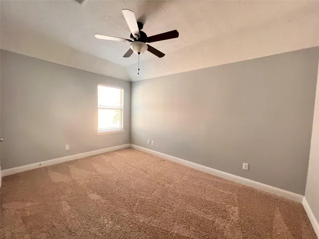 an empty room with a window and a fan