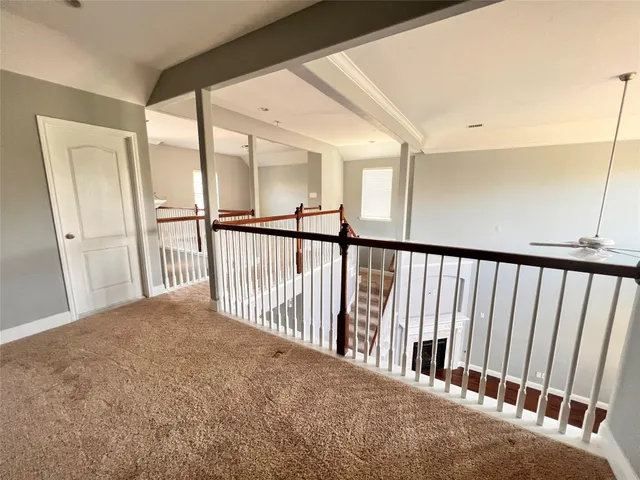 an empty room with ceiling fan and window