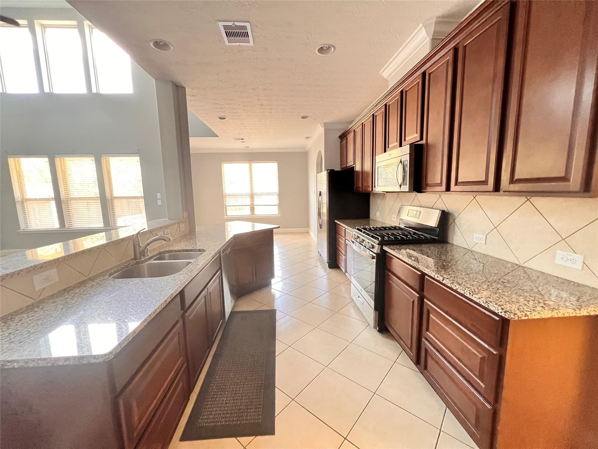 26842 Trinity Trail Cypress, TX 77433 - Photo 28 of 31 a kitchen with stainless steel appliances granite countertop a sink stove and cabinets