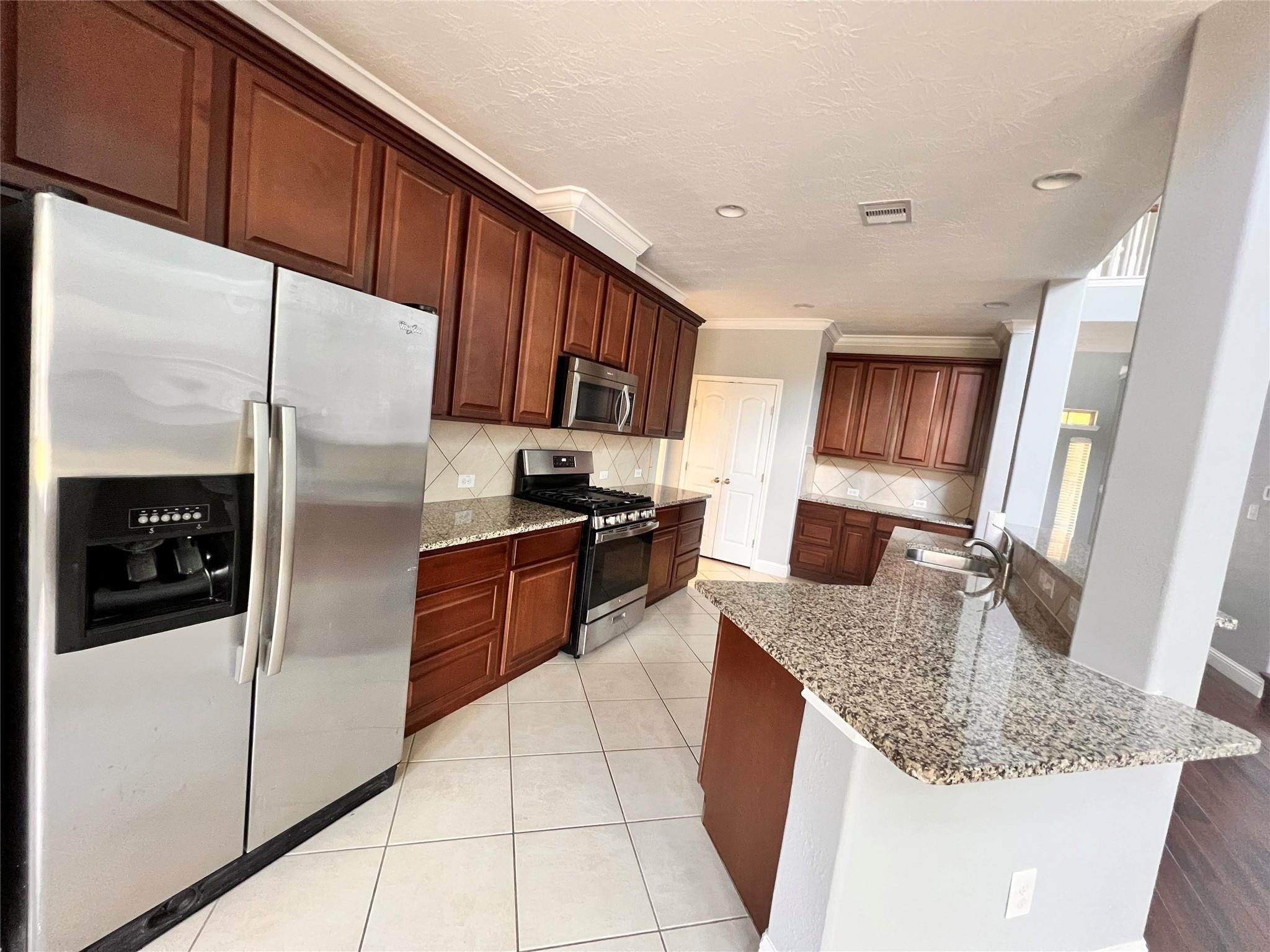 26842 Trinity Trail Cypress, TX 77433 - Photo 7 of 31 a large kitchen with granite countertop a large counter top stainless steel appliances and cabinets