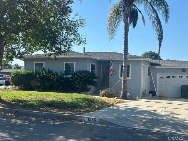 a view of a house with backyard and tree