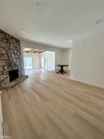 a view of an empty room with a fireplace and a window