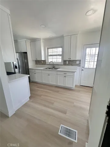 a kitchen with granite countertop a stove a sink and a refrigerator