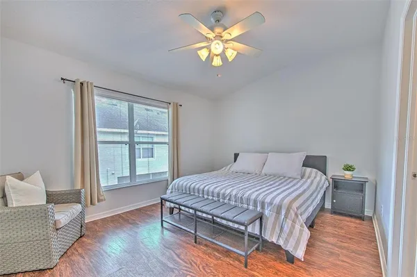 a bedroom with a bed table chair and a window