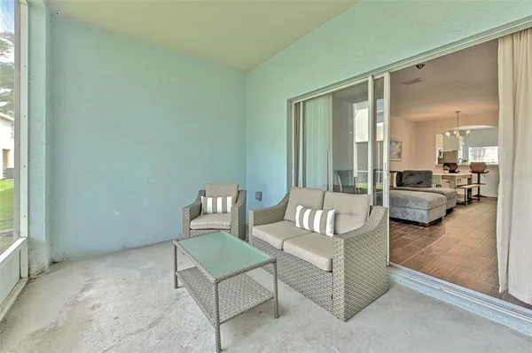 a living room with furniture and a large mirror next to a window