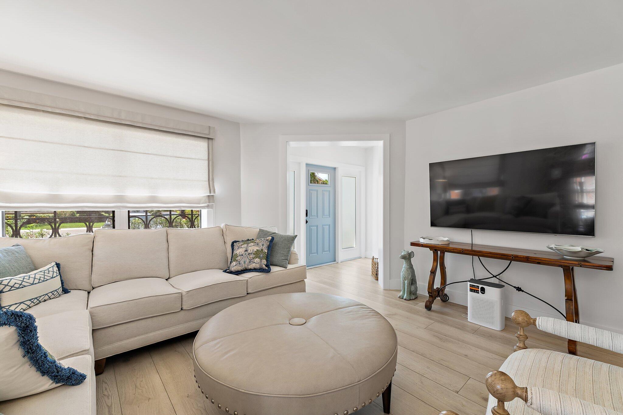 15 Uno Lago Drive, Unit 15 Juno Beach, FL 33408 - Photo 12 of 50 a living room with furniture and a flat screen tv