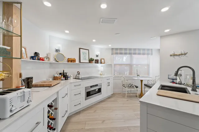 a kitchen with white cabinets stove and sink
