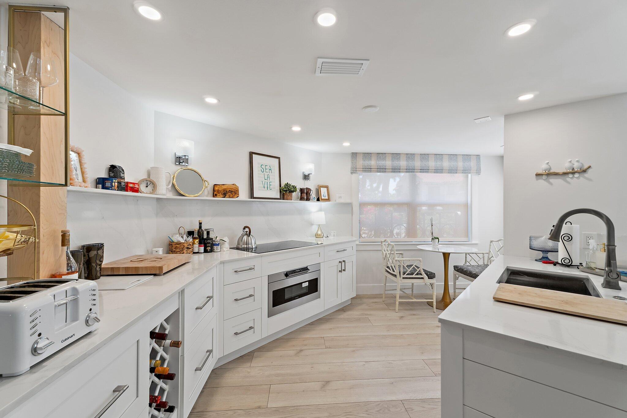 15 Uno Lago Drive, Unit 15 Juno Beach, FL 33408 - Photo 15 of 50 a kitchen with white cabinets stove and sink